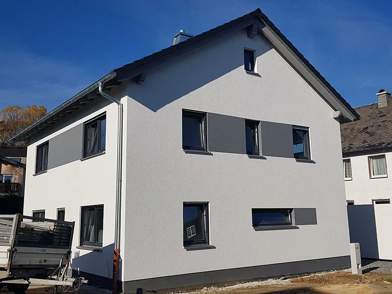 Weißer Neubau mit Satteldach