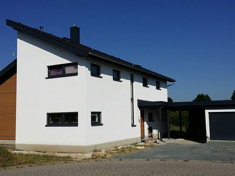 Weißes Einfamilienhaus mit Carport