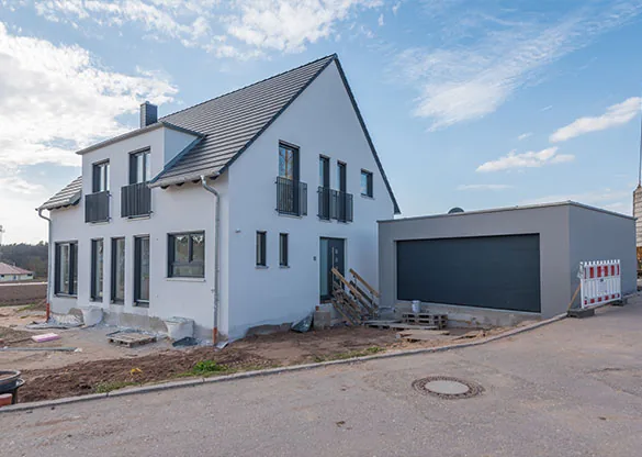 Weißer Neubau mit Doppelgarage