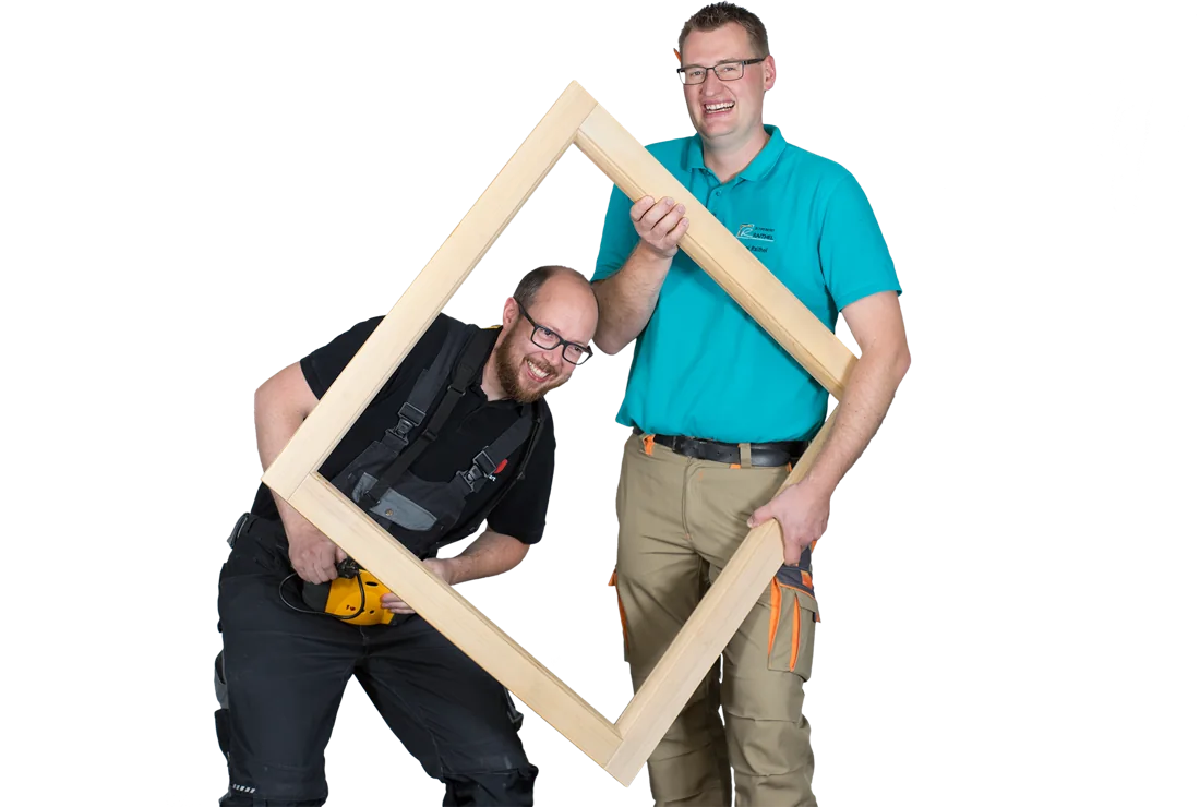 Zwei Handwerker der HarmonieBau lachend mit einem Holzrahmen